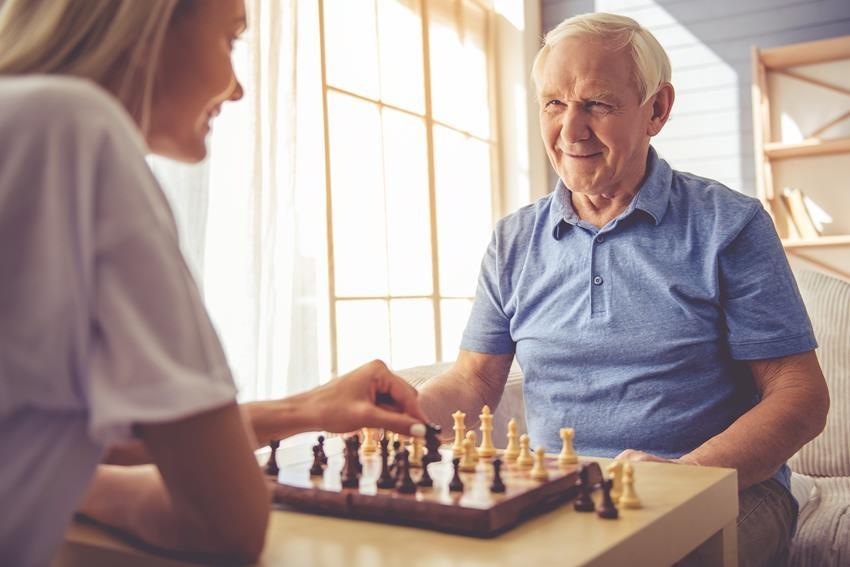 opiekunka grająca w szachy ze starszą osobą